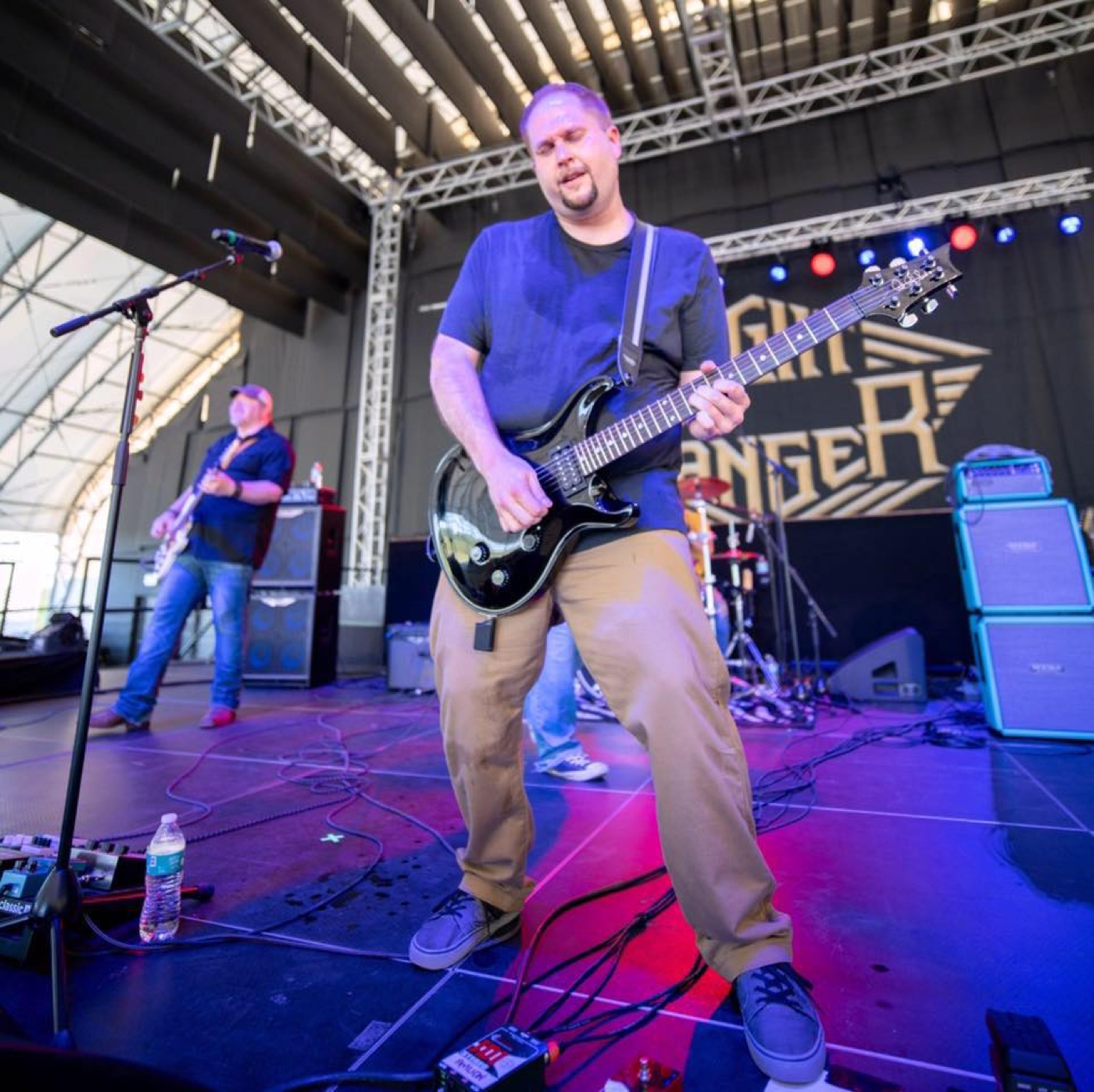 Alex Fernandez performing on stage with guitar